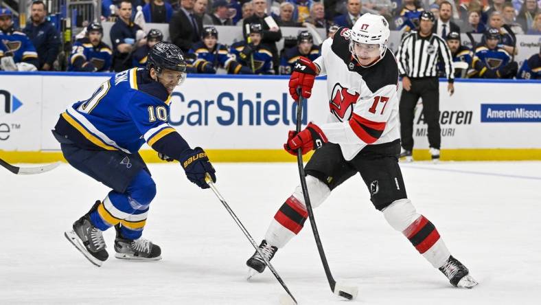 Feb 16, 2023; St. Louis, Missouri, USA;  New Jersey Devils center Yegor Sharangovich (17) shoots as St. Louis Blues center Brayden Schenn (10) defends during the first period at Enterprise Center. Mandatory Credit: Jeff Curry-USA TODAY Sports