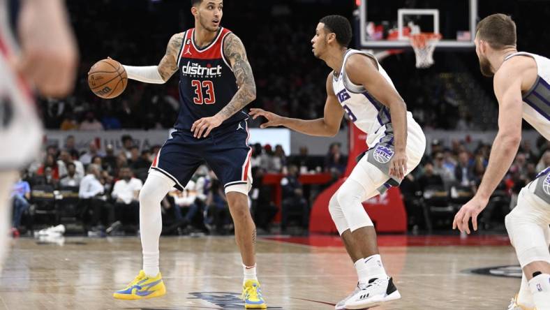 Mar 18, 2023; Washington, District of Columbia, USA; Washington Wizards forward Kyle Kuzma (33) dribbles as Sacramento Kings forward Keegan Murray (13) defends during the second half at Capital One Arena. Mandatory Credit: Brad Mills-USA TODAY Sports