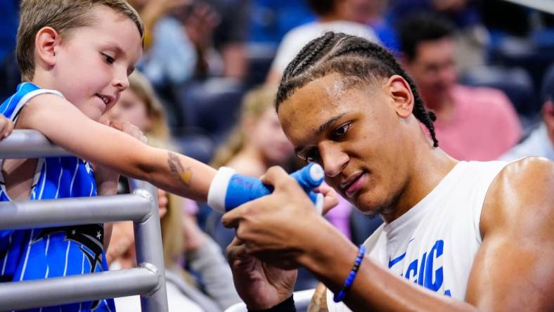 Apr 2, 2023; Orlando, Florida, USA;  Orlando Magic forward Paolo Banchero (5) signs a fans cast prior to a game against the Detroit Pistons at Amway Center. Mandatory Credit: Rich Storry-USA TODAY Sports