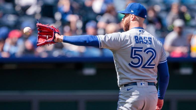 Apr 6, 2023; Kansas City, Missouri, USA; Toronto Blue Jays relief pitcher Anthony Bass (52) reaches for a throw during the seventh inning against the Kansas City Royals at Kauffman Stadium. Mandatory Credit: William Purnell-USA TODAY Sports