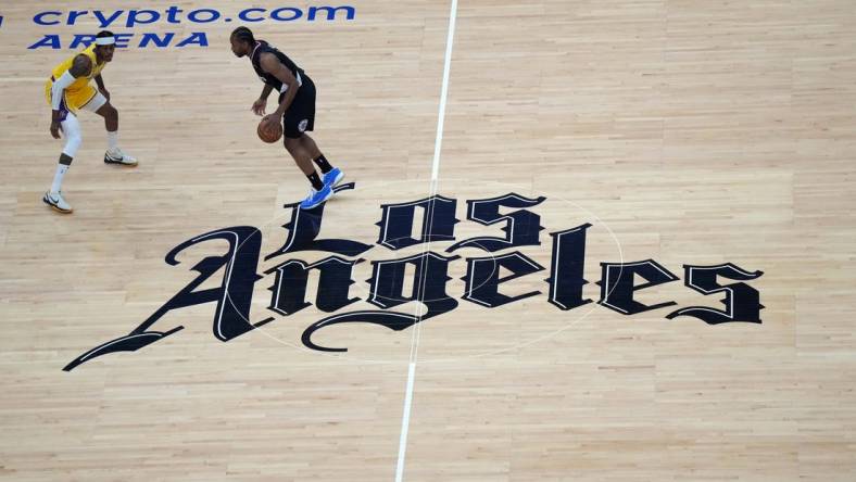 Apr 5, 2023; Los Angeles, California, USA; A general overall view as LA Clippers forward Kawhi Leonard (2) dribbles the ball against Los Angeles Lakers forward Jarred Vanderbilt (2) at midcourt on the Clippers Los Angeles logo in the first half at Crypto.com Arena. Mandatory Credit: Kirby Lee-USA TODAY Sports