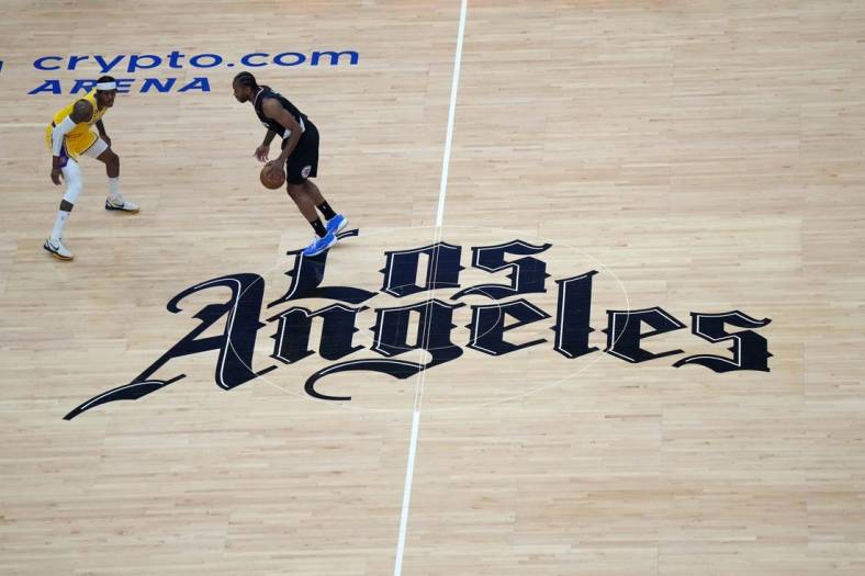 Apr 5, 2023; Los Angeles, California, USA; A general overall view as LA Clippers forward Kawhi Leonard (2) dribbles the ball against Los Angeles Lakers forward Jarred Vanderbilt (2) at midcourt on the Clippers Los Angeles logo in the first half at Crypto.com Arena. Mandatory Credit: Kirby Lee-USA TODAY Sports