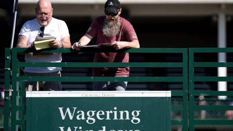 May 5, 2023; Louisville, KY, USA; Keith Shaffer and his son, Keith Shaffer Jr., prepare to make bets at Churchill Downs on Oaks Day, Friday, May 5, 2023, in Louisville, Ky. Mandatory Credit: Albert Cesare-USA TODAY Sports