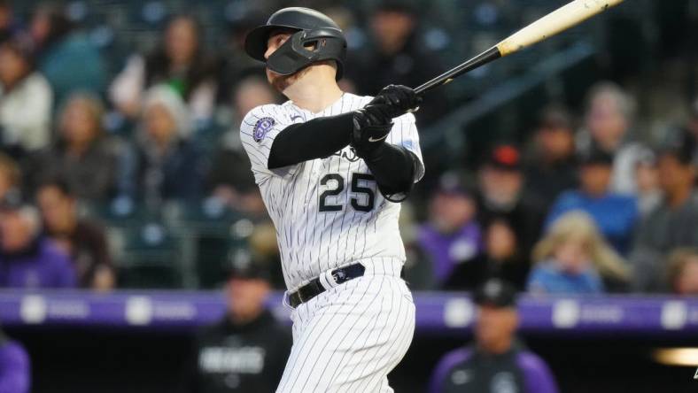 May 12, 2023; Denver, Colorado, USA; Colorado Rockies first baseman C.J. Cron (25) hits a RBI sacrifice fly in the sixth inning against the Philadelphia Phillies at Coors Field. Mandatory Credit: Ron Chenoy-USA TODAY Sports