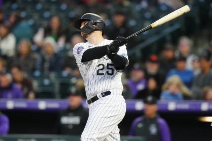 May 12, 2023; Denver, Colorado, USA; Colorado Rockies first baseman C.J. Cron (25) hits a RBI sacrifice fly in the sixth inning against the Philadelphia Phillies at Coors Field. Mandatory Credit: Ron Chenoy-USA TODAY Sports