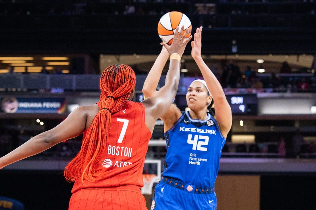 May 19, 2023; Indianapolis, Indiana, USA; Connecticut Sun center Brionna Jones (42) shoots the ball while Indiana Fever forward Aliyah Boston (7) defends in the first half at Gainbridge Fieldhouse. Mandatory Credit: Trevor Ruszkowski-USA TODAY Sports