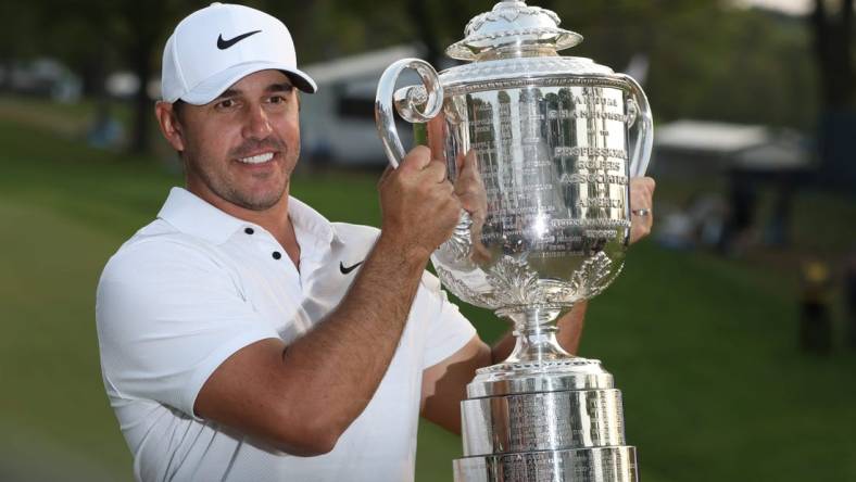 Brooks Koepka poses with the Wanamaker Trophy on the 18th green following his victory at the PGA Championship at Oak Hill Country Club Sunday, May 21, 2023.