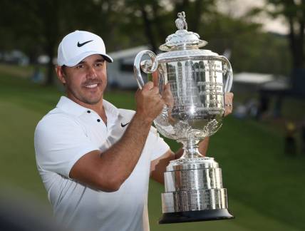 Brooks Koepka poses with the Wanamaker Trophy on the 18th green following his victory at the PGA Championship at Oak Hill Country Club Sunday, May 21, 2023.