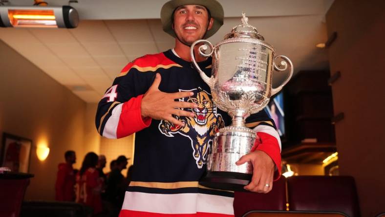 May 22, 2023; Sunrise, Florida, USA; Pro golfer Brooks Koepka poses with the Wanamaker Trophy while attending Game 3 of the Eastern Conference Finals of the 2023 Stanley Cup Playoffs between the Florida Panthers and the Carolina Hurricanes at FLA Live Arena. Mandatory Credit: Jasen Vinlove-USA TODAY Sports