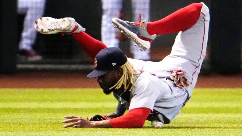 Boston Red Sox left fielder Raimel Tapia (17) rolls over the ball after missing a diving catch on a fly ball from Arizona Diamondbacks Jake McCarthy in the fifth inning at Chase Field in Phoenix on May 27, 2023.