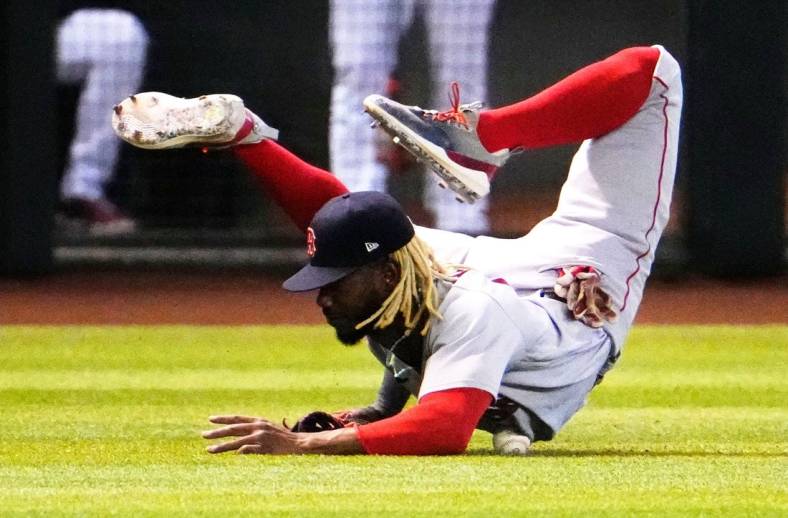 Boston Red Sox left fielder Raimel Tapia (17) rolls over the ball after missing a diving catch on a fly ball from Arizona Diamondbacks Jake McCarthy in the fifth inning at Chase Field in Phoenix on May 27, 2023.