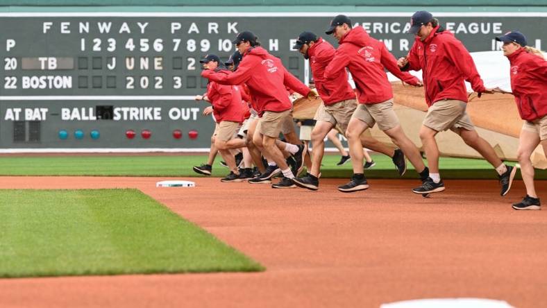 Jun 2, 2023; Boston, Massachusetts, USA; Grounds crew pull a tarp on the field before a game between the Tampa Bay Rays and the Boston Red Sox at Fenway Park. Mandatory Credit: Brian Fluharty-USA TODAY Sports