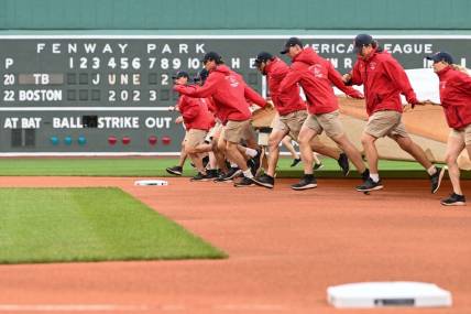 Jun 2, 2023; Boston, Massachusetts, USA; Grounds crew pull a tarp on the field before a game between the Tampa Bay Rays and the Boston Red Sox at Fenway Park. Mandatory Credit: Brian Fluharty-USA TODAY Sports
