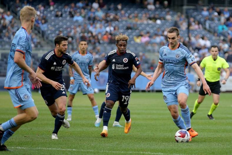 Jun 3, 2023; New York, New York, USA; New York City FC midfielder James Sands (6) brings the ball up the pitch against New England Revolution forward Latif Blessing (19) and midfielder Matt Polster (8) during the first half at Yankee Stadium. Mandatory Credit: Brad Penner-USA TODAY Sports