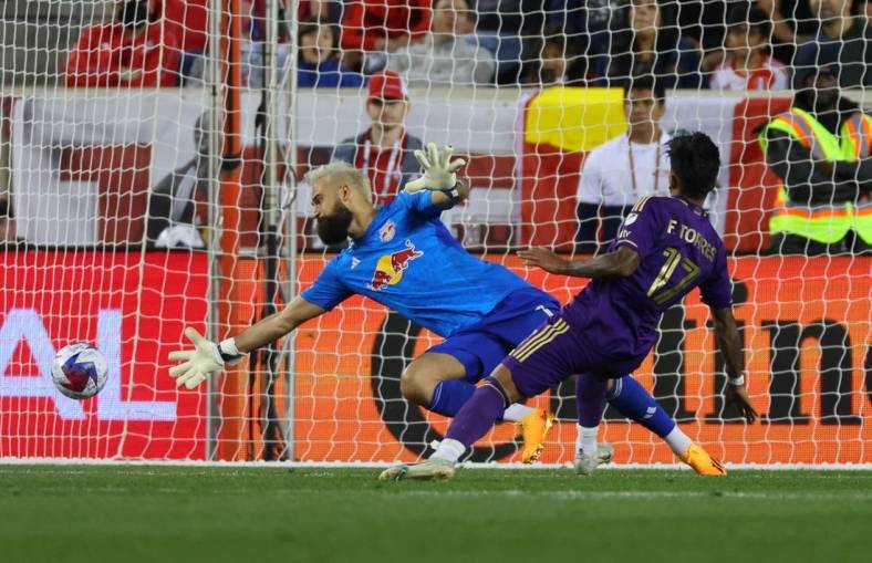 Jun 3, 2023; Harrison, New Jersey, USA;  Orlando City forward Facundo Torres (17) scores a goal past New York Red Bulls goalkeeper Carlos Miguel Coronel (1) in the second half at Red Bull Arena. Mandatory Credit: Vincent Carchietta-USA TODAY Sports