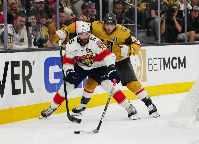Jun 3, 2023; Las Vegas, Nevada, USA; Florida Panthers defenseman Aaron Ekblad (5) controls the puck against Vegas Golden Knights center Ivan Barbashev (49) during the second period in game one of the 2023 Stanley Cup Final at T-Mobile Arena. Mandatory Credit: Stephen R. Sylvanie-USA TODAY Sports