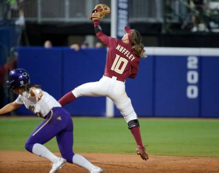 Florida State's Josie Muffley (10) makes a line drive catch behind Washington's Megan Vandegrift (2) in the seventh inning during a softball game between Washington and Florida State in the Women's College World Series at USA Softball Hall of Fame Stadium in  in Oklahoma City, Saturday, June, 3, 2023.