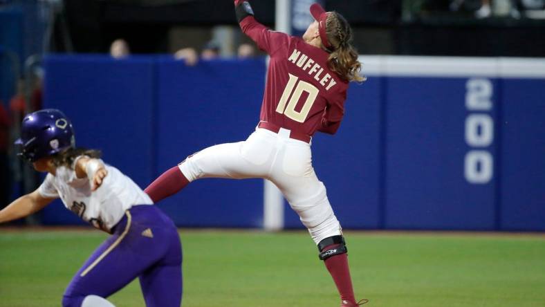 Florida State's Josie Muffley (10) makes a line drive catch behind Washington's Megan Vandegrift (2) in the seventh inning during a softball game between Washington and Florida State in the Women's College World Series at USA Softball Hall of Fame Stadium in  in Oklahoma City, Saturday, June, 3, 2023.