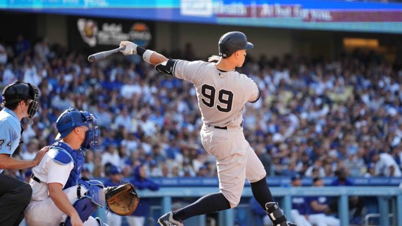 Jun 3, 2023; Los Angeles, California, USA; New York Yankees right fielder Aaron Judge (99) follows through on a home run in the sixth inning as Los Angeles Dodgers catcher Will Smith (16) and home plate umpire John Tumpane (74) watch at Dodger Stadium. Mandatory Credit: Kirby Lee-USA TODAY Sports