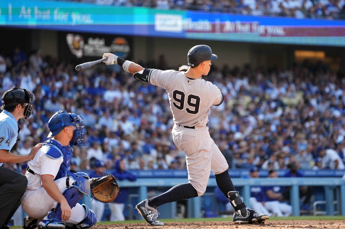 Jun 3, 2023; Los Angeles, California, USA; New York Yankees right fielder Aaron Judge (99) follows through on a home run in the sixth inning as Los Angeles Dodgers catcher Will Smith (16) and home plate umpire John Tumpane (74) watch at Dodger Stadium. Mandatory Credit: Kirby Lee-USA TODAY Sports