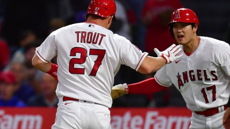 Jun 6, 2023; Anaheim, California, USA; Los Angeles Angels center fielder Mike Trout (27) is greeted by designated hitter Shohei Ohtani (17) after scoring a run against the Chicago Cubs during the fifth inning at Angel Stadium. Mandatory Credit: Gary A. Vasquez-USA TODAY Sports