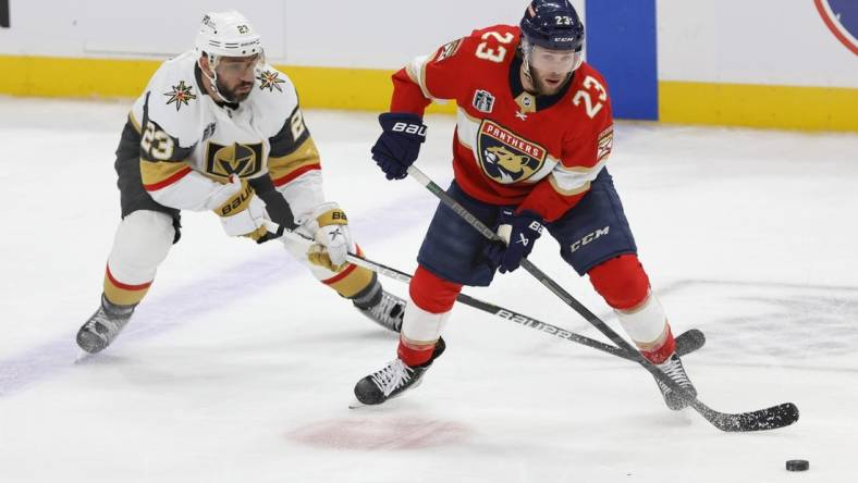 Jun 8, 2023; Sunrise, Florida, USA; Florida Panthers center Carter Verhaeghe (23) controls the puck in front of Vegas Golden Knights defenseman Alec Martinez (23) during the third period in game three of the 2023 Stanley Cup Final at FLA Live Arena. Mandatory Credit: Sam Navarro-USA TODAY Sports