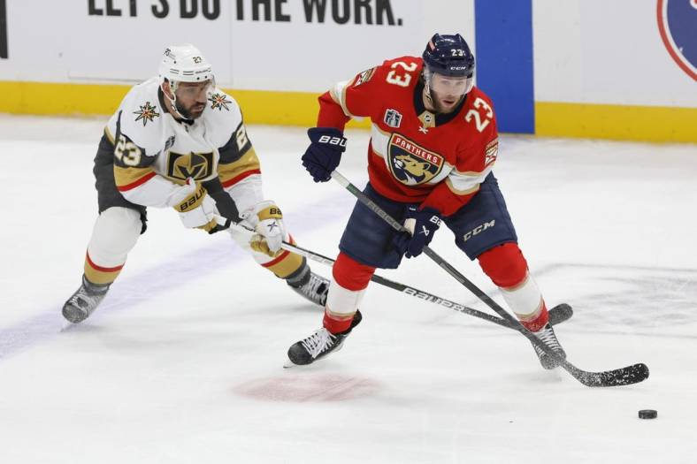 Jun 8, 2023; Sunrise, Florida, USA; Florida Panthers center Carter Verhaeghe (23) controls the puck in front of Vegas Golden Knights defenseman Alec Martinez (23) during the third period in game three of the 2023 Stanley Cup Final at FLA Live Arena. Mandatory Credit: Sam Navarro-USA TODAY Sports