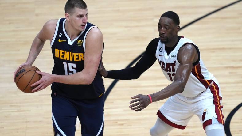 Jun 9, 2023; Miami, Florida, USA; Denver Nuggets center Nikola Jokic (15) controls the ball while defended by Miami Heat center Bam Adebayo (13) during the second half in game four of the 2023 NBA Finals at Kaseya Center. Mandatory Credit: Jim Rassol-USA TODAY Sports