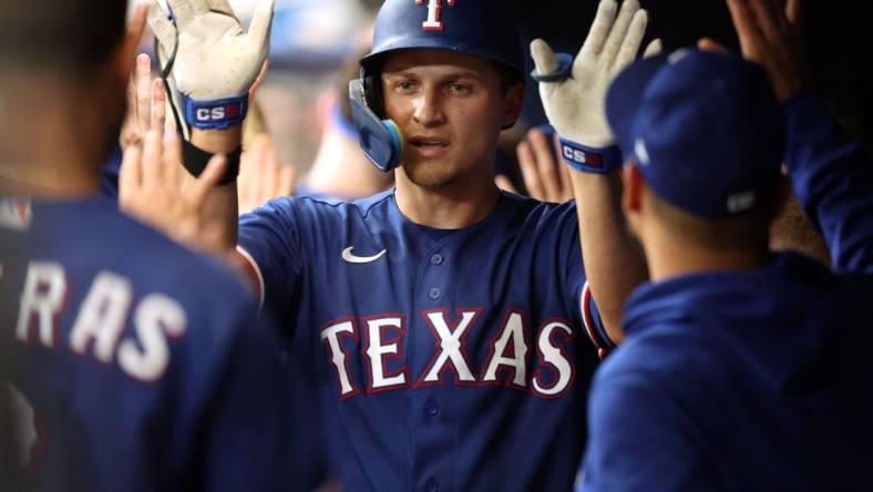 Jun 10, 2023; St. Petersburg, Florida, USA;  Texas Rangers shortstop Corey Seager (5) is congratulated in the dugout after hitting a 2-run home run against the Tampa Bay Rays during the fourth inning at Tropicana Field. Mandatory Credit: Kim Klement-USA TODAY Sports