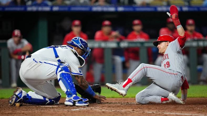 Jun 12, 2023; Kansas City, Missouri, USA; Cincinnati Reds center fielder TJ Friedl (29) slides into home to score the go-ahead run ahead of the tag by Kansas City Royals catcher Salvador Perez (13) during the tenth inning at Kauffman Stadium. Mandatory Credit: Jay Biggerstaff-USA TODAY Sports