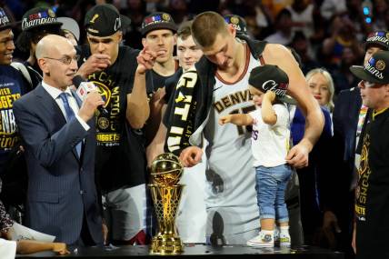 Jun 12, 2023; Denver, Colorado, USA; Denver Nuggets center Nikola Jokic (15) and his daughter point to the Bill Russell NBA Finals MVP Award trophy after winning the 2023 NBA Finals against the Miami Heat at Ball Arena. Mandatory Credit: Kyle Terada-USA TODAY Sports