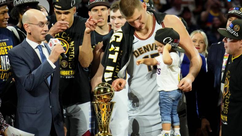 Jun 12, 2023; Denver, Colorado, USA; Denver Nuggets center Nikola Jokic (15) and his daughter point to the Bill Russell NBA Finals MVP Award trophy after winning the 2023 NBA Finals against the Miami Heat at Ball Arena. Mandatory Credit: Kyle Terada-USA TODAY Sports