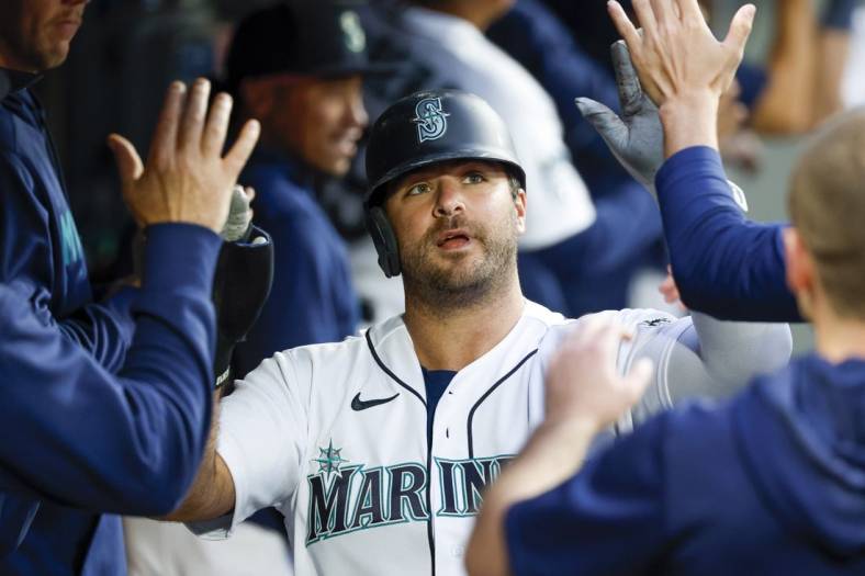 Jun 13, 2023; Seattle, Washington, USA; Seattle Mariners designated hitter Mike Ford (20) high-fives teammates in the dugout after scoring a run against the Miami Marlins during the sixth inning at T-Mobile Park. Mandatory Credit: Joe Nicholson-USA TODAY Sports