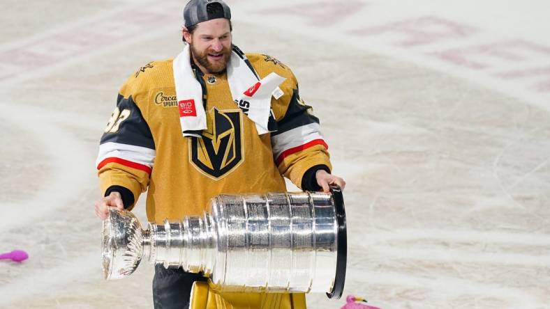 Jun 13, 2023; Las Vegas, Nevada, USA; Vegas Golden Knights goaltender Adin Hill (33) hoists the Stanley Cup after defeating the Florida Panthers in game five of the 2023 Stanley Cup Final at T-Mobile Arena. Mandatory Credit: Lucas Peltier-USA TODAY Sports