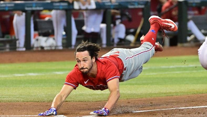 Jun 15, 2023; Phoenix, Arizona, USA;  Philadelphia Phillies catcher Garrett Stubbs (21) slides and scores in the fourth inning against the Arizona Diamondbacks at Chase Field. Mandatory Credit: Matt Kartozian-USA TODAY Sports