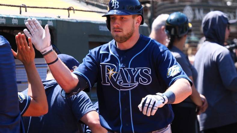 Jun 15, 2023; Oakland, California, USA; Tampa Bay Rays first baseman Luke Raley (55) high fives teammates after hitting a solo home run against the Oakland Athletics during the eighth inning at Oakland-Alameda County Coliseum. Mandatory Credit: Kelley L Cox-USA TODAY Sports