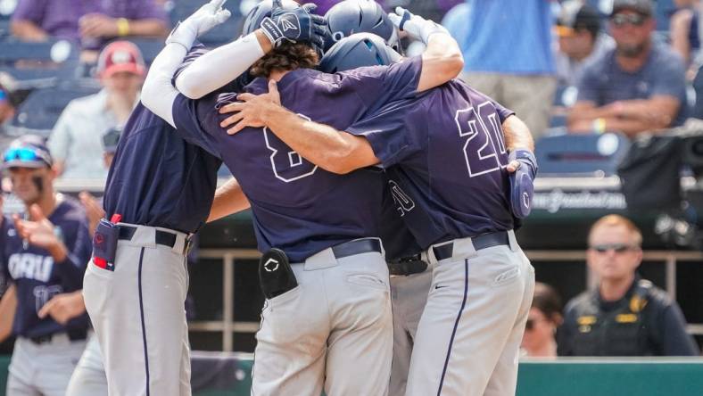 Jun 16, 2023; Omaha, NE, USA; Oral Roberts Golden Eagles second baseman Blaze Brothers (8), outfielder Sam Thompson (20), first baseman Jake McMurray (4) and third baseman Holden Breeze (5) celebrate after a three-run home run by Brothers during the ninth inning at Charles Schwab Field Omaha. Mandatory Credit: Dylan Widger-USA TODAY Sports