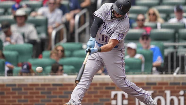 Jun 18, 2023; Cumberland, Georgia, USA; Colorado Rockies first baseman Mike Moustakas (11) singles against the Atlanta Braves during the second inning at Truist Park. Mandatory Credit: Dale Zanine-USA TODAY Sports