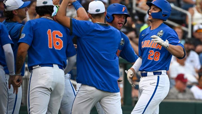 Jun 18, 2023; Omaha, NE, USA;  Florida Gators designated hitter Luke Heyman (28) greets teammates after hitting a home run against the Oral Roberts Golden Eagles in the fourth inning at Charles Schwab Field Omaha. Mandatory Credit: Steven Branscombe-USA TODAY Sports