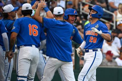 Jun 18, 2023; Omaha, NE, USA;  Florida Gators designated hitter Luke Heyman (28) greets teammates after hitting a home run against the Oral Roberts Golden Eagles in the fourth inning at Charles Schwab Field Omaha. Mandatory Credit: Steven Branscombe-USA TODAY Sports