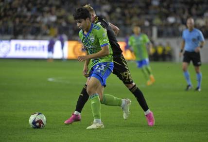 Jun 21, 2023; Los Angeles, California, USA; Seattle Sounders midfielder Obed Vargas (73) runs with the ball against Los Angeles FC player Mateusz Bogusz (19) during the game at BMO Stadium. Mandatory Credit: Jayne Kamin-Oncea-USA TODAY Sports