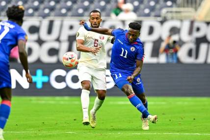 Jun 25, 2023; Houston, Texas, USA; Haiti forward Derrick Etienne (11) and Qatar midfielder Ahmed Abdoulla (6) battle for possession during the first half at NRG Stadium. Mandatory Credit: Maria Lysaker-USA TODAY Sports