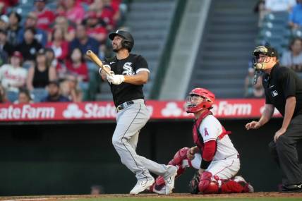 Jun 28, 2023; Anaheim, California, USA; Chicago White Sox catcher Seby Zavala (44) follows through on a home run in the second inning as Los Angeles Angels catcher Chad Wallach (35) and home plate umpire Chad Whiston watch at Angel Stadium. Mandatory Credit: Kirby Lee-USA TODAY Sports