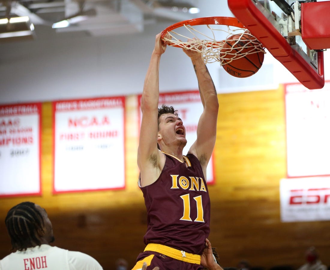 Iona's Quinn Slazinski slam dunks on Marist's Victor Enoh during Wednesday's game in Poughkeepsie on December 1, 2021.

Marist Vs Iona Basketball