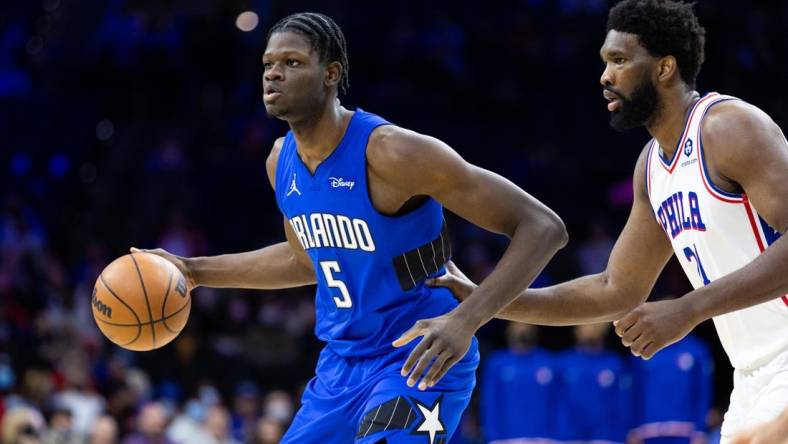 Jan 19, 2022; Philadelphia, Pennsylvania, USA; Orlando Magic center Mo Bamba (5) dribbles the ball against Philadelphia 76ers center Joel Embiid (21) during the third quarter at Wells Fargo Center. Mandatory Credit: Bill Streicher-USA TODAY Sports