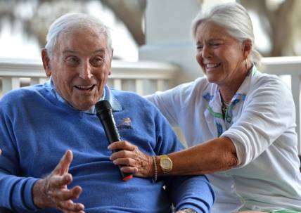 Mary Lujack, right, holds a microphone for her father, Johnny Lujack, winner of the 1947 Heisman Memorial Trophy at The Founder's Club on Tuesday. Lujack spoke to members on the veranda of the clubhouse after accompanying his daughter and some of her friends on the golf course.

Sar Lujack Heisman 001