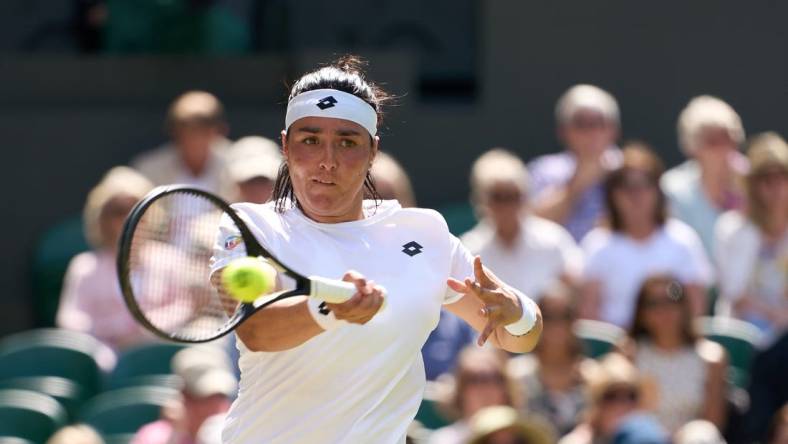 Jul 7, 2022; London, England, United Kingdom;  
Ons Jabeur (TUN) returns a shot during  her semi finals women   s singles match against Tatjana Maria (GER) on Centre court at All England Lawn Tennis and Croquet Club. Mandatory Credit: Peter van den Berg-USA TODAY Sports