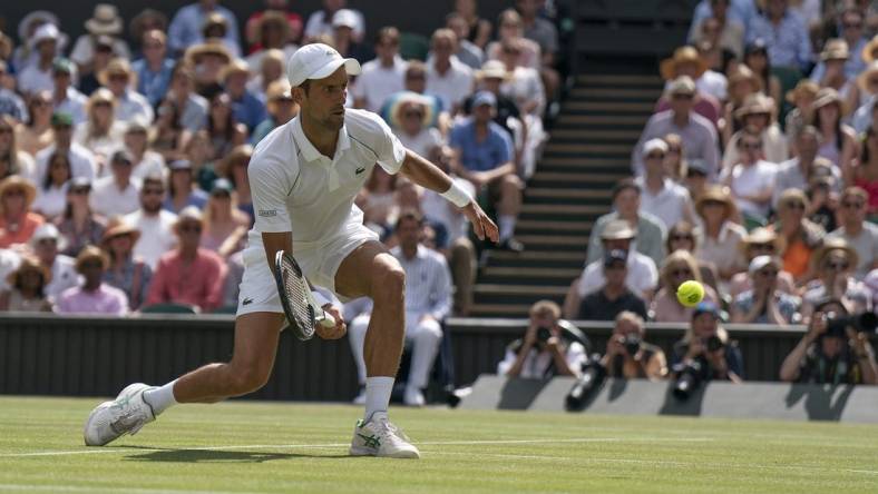 Jul 10, 2022; London, United Kingdom; Novak Djokovic (SRB) returns a shot during the men   s final against Nick Kyrgios (not pictured) on day 14 at All England Lawn Tennis and Croquet Club. Mandatory Credit: Susan Mullane-USA TODAY Sports