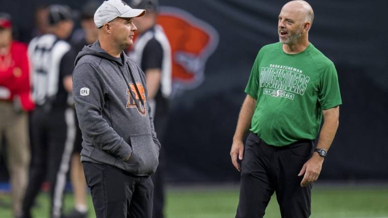 Aug 26, 2022; Vancouver, British Columbia, CAN; BC Lions head coach Rick Campbell (left) and Saskatchewan Roughriders head coach Craig Dickenson talk during warmups at BC Place. Mandatory Credit: Bob Frid-USA TODAY Sports