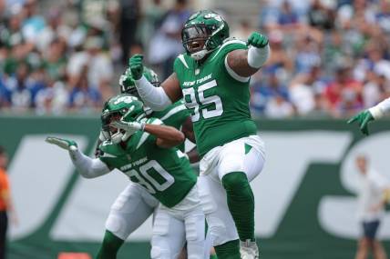 Aug 28, 2022; East Rutherford, New Jersey, USA; New York Jets defensive tackle Quinnen Williams (95) celebrates his sack with cornerback Michael Carter II (30) during the first half against the New York Giants at MetLife Stadium. Mandatory Credit: Vincent Carchietta-USA TODAY Sports